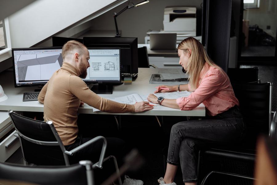Two colleagues reviewing plans together in a design studio