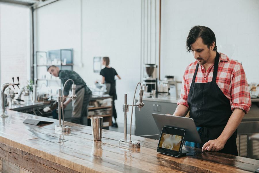 Café owner ringing up an order on a tablet register