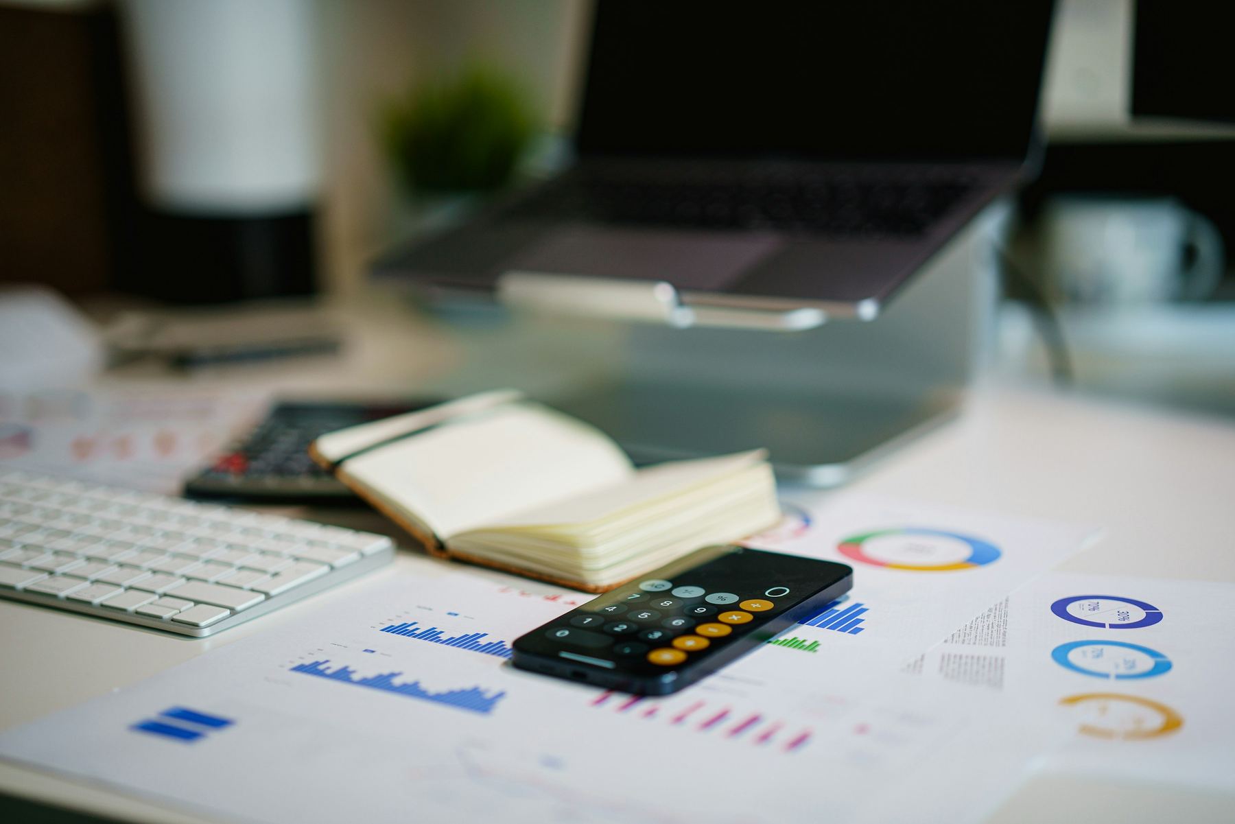 Printed financial charts and a calculator on a desk
