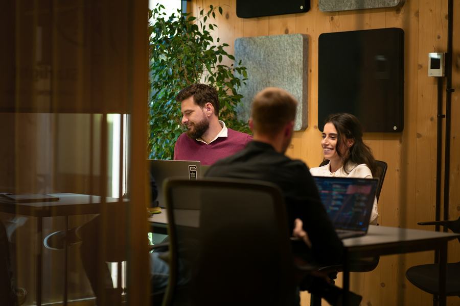 Startup team working on laptops in a wood-panelled office